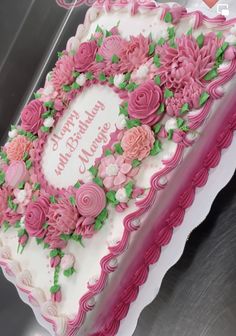 a birthday cake decorated with pink flowers and greenery