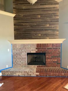 a brick fireplace with blue tape on the mantle and wood paneling in the back