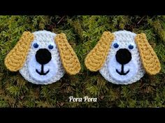 two crocheted dogs with blue eyes laying in the grass