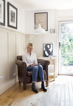 a woman sitting in a chair reading a book