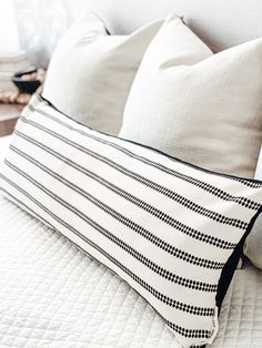 a white bed with black and white pillows