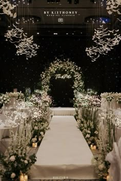 an aisle decorated with white flowers and greenery at the end of a wedding ceremony