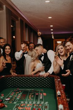 a group of people standing around a casino table