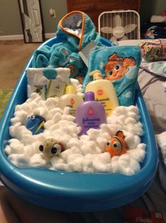 a bath tub filled with lots of toys on top of a bed in a room