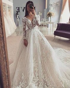 a woman in a wedding dress taking a selfie with her cell phone while standing in front of a mirror