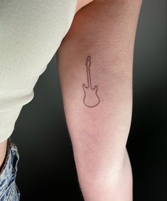 a person with a guitar tattoo on their arm