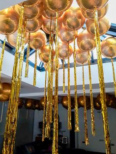 a room filled with lots of shiny gold balls and streamers hanging from the ceiling