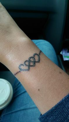 a person with a tattoo on their arm that has two hearts in the shape of an arrow