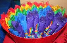 a red bucket filled with lots of colorful plastic forks