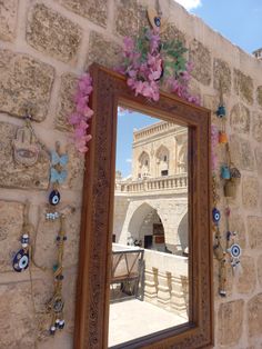 a mirror hanging on the side of a stone wall