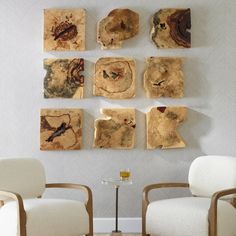 several pieces of wood are arranged on the wall above two chairs in front of them