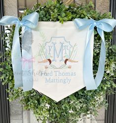 a wreath with blue ribbon around it and the words, lord thomas matingly