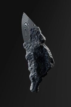 a piece of rock with a knife sticking out of it's side on a black background