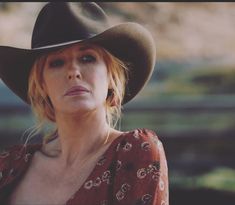 a woman wearing a cowboy hat looking at the camera