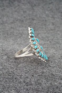 This turquoise and sterling silver ring was made by Zuni silversmith Milburn Dishta. The back is stamped M. Dishta, and Zuni, N.Mex.Size: 9Length: 1 1/4"Width: 7/8"Free shipping on all orders! We ship with USPS and always include tracking. All orders ship within a day of payment.Returns are accepted up to 30 days after you receive your order. Just send us a message. Our shop offers cash back or store credit. The item must be returned in new condition. Southwestern Silver Turquoise Open Ring, Southwestern Style Silver Turquoise Open Ring, Southwestern Style Silver Open Turquoise Ring, Southwestern Open Turquoise Ring, Spring Sale, Turquoise Sterling Silver, Sterling Silver Ring, Silver Ring, Sterling Silver Rings