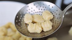 a metal strainer filled with bananas next to a bowl full of other food items