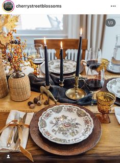 an image of a table setting with candles and dishes on it for thanksgiving dinner party