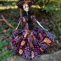 a skeleton doll wearing a colorful dress and hat