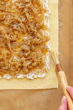 a person is making food on a piece of paper with a spatula in front of it