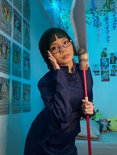 a woman with glasses holding a large red handled baseball bat in front of her face