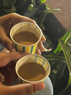 two people holding cups of coffee in their hands