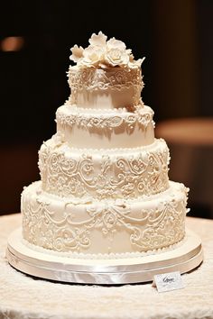 Elegant four-tier white wedding cake with intricate floral designs. Fondant Bows, Wedding Cake Designs Elegant, Cake Roses, Perfect Wedding Cake, Bridal Cake, Inside Cake, Edible Lace, Wedding Cake Roses