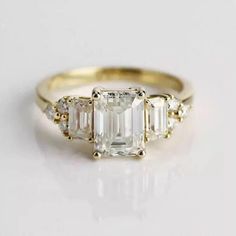 three stone diamond ring in yellow gold with baguets on the sides and side stones