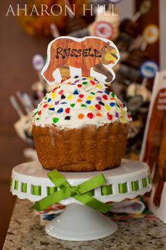 a cake with frosting and sprinkles sitting on top of a table