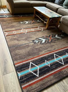 a living room area with couches and rugs on the floor, including a coffee table