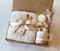 a gift box with a coffee mug, spoon and napkin