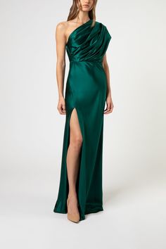 a woman in a green dress with one leg slited up and the other side split open