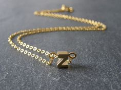 A tiny matt gold plated initial letter 'Z' pendant dangles from a fine gold plated chain necklace.  Simple and modern. Initial 'Z' pendant is matt gold plated, double sided, tarnish resistant, size - 5 x 7mm Fine link chain necklace is gold plated, various sizes available, please select the length you require above. Other alphabet letters available - A-Z in gold and silver: Gold personalized initial necklace, choose your initial:- https://www.etsy.com/listing/129735775/tiny-initial-letter-matt-gold-necklace?ref=shop_home_active Silver personalized initial necklace, choose your initial:- https://www.etsy.com/listing/129735289/tiny-silver-initial-letter-necklace?ref=shop_home_active ★ All items arrive in a gift box with ribbon.  Ready to ship.  Personalized messages and direct shipping to th Z Necklace Letter Gold, Z Necklace, Gold Letter Necklace, Gold Letter, Letter Z, Necklace Simple, Link Chain Necklace, Gold Initial, Alphabet Letters