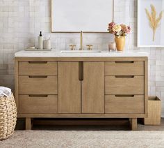 a bathroom vanity with two sinks and a large mirror above it, in front of a white brick wall