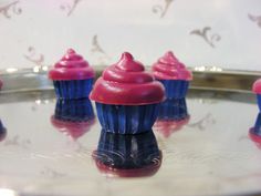 three blue and pink cupcakes sitting on top of a table