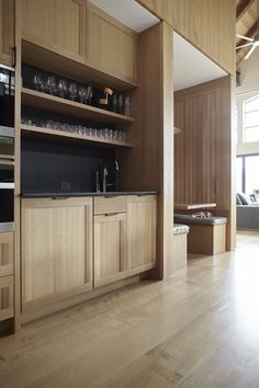 an open kitchen with wooden cabinets and black counter tops, along with hardwood flooring