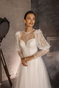 a woman in a wedding dress standing next to a camera