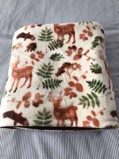 a blanket with animals and leaves on it