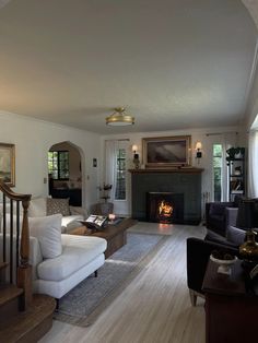 a living room filled with furniture and a fire place in the middle of the room