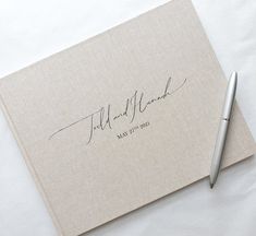 a wedding guest book and pen on a white tablecloth with the words fill and blank