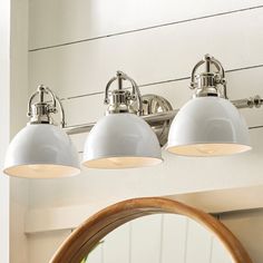 three light bathroom fixture with white glass shades on the top and bottom lights above it