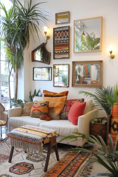 a living room filled with lots of plants and pictures hanging on the wall above it