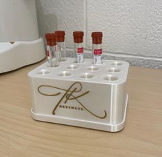 four tubes in a holder on a table