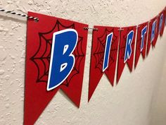 red and blue spider web banner hanging on the wall in a school hallway for birthdays