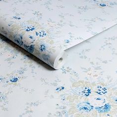 a blue and white flowered wallpaper with flowers on the bottom half of it