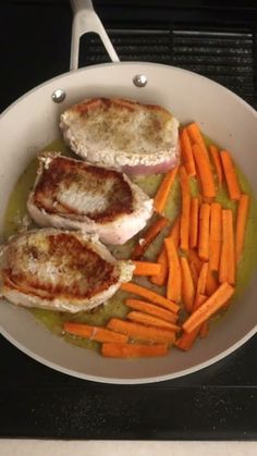 some meat and carrots in a pan on the stove