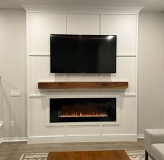 a living room with a tv mounted on the wall and a fire place in front of it