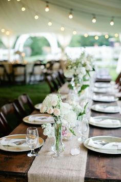 a long table set with plates and flowers