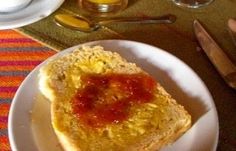 a piece of bread with jam on it sitting on a plate next to a knife and fork