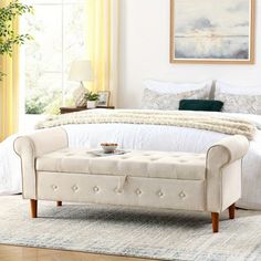 a white bed sitting in a bedroom next to a window with yellow drapes on the windowsill