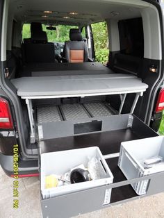 the back end of a van with its trunk open and two trays in it